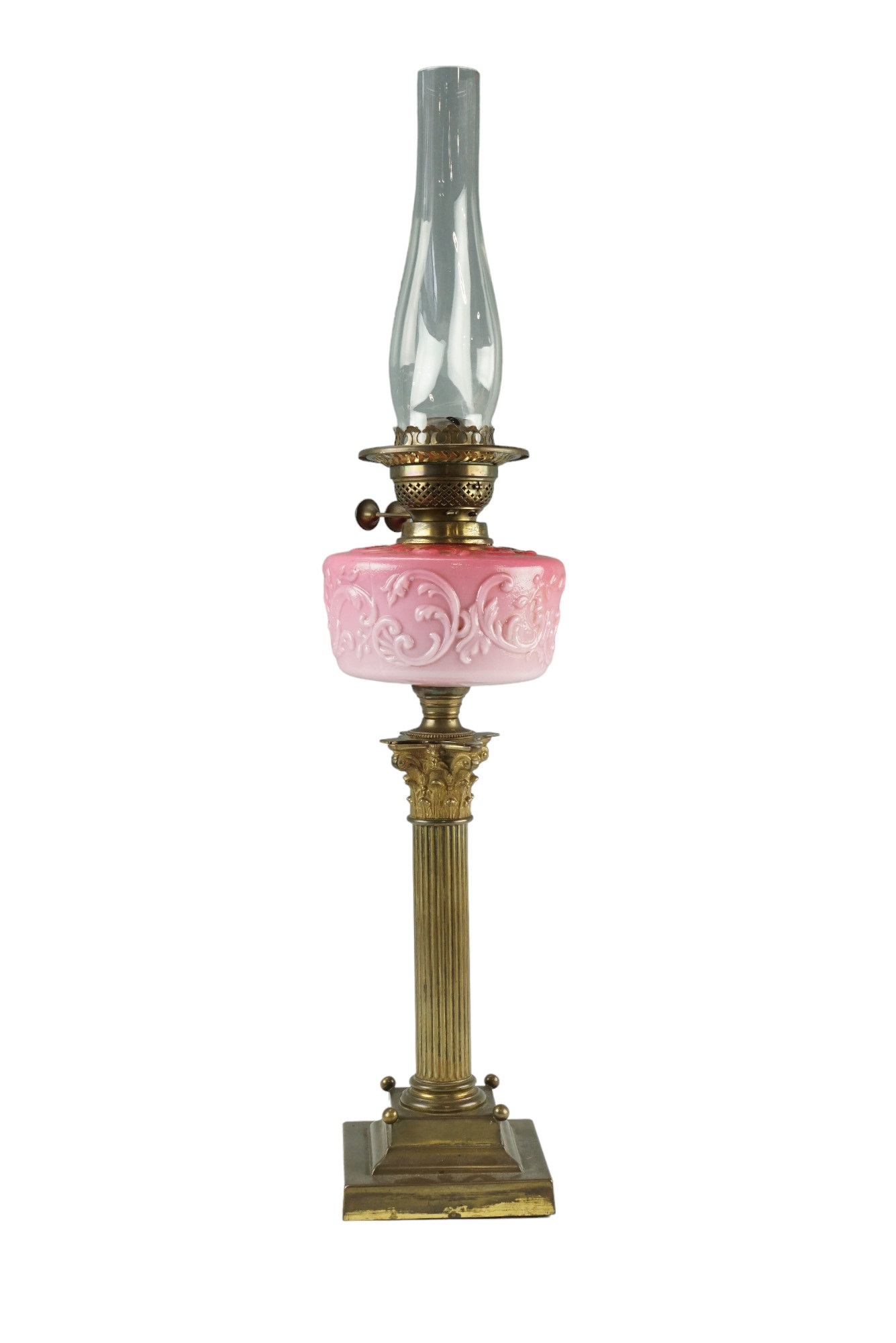 A Victorian columnar oil lamp, having a Duplex burner and floral-scroll-moulded pink opaline glass