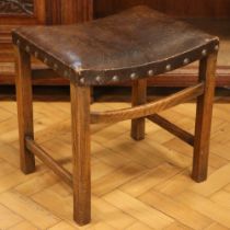 A George V oak dressing table stool, having a period leatherette-upholstered saddle seat with