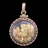 A gold nugget pendant, the nuggets loose under glass within a circular cannetille-bordered yellow