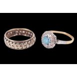 A spinel and diamond finger ring, having a 5 mm round spinel set in a stepped white metal bezel,