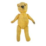 An early 20th Century straw-filled teddy bear with articulated limbs and glass eyes, 30 cm