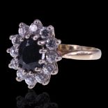A 1980s sapphire and white stone cluster ring, the central oval-cut sapphire of approx 1 ct, claw-