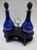 Pair of Georgian Bristol blue glass rum and brandy decanters on an ebonised and gilt brass mounted