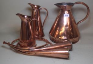 Antique copper measure, two copper jugs, two horns and a small copper lamp