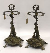 Pair of ornate brass stick stands mounted with figures of dogs, 56cm high