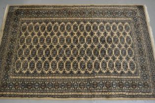 Pakistan rug of Turkoman design with four rows of gols on a beige ground, 234 x 156cm approximately