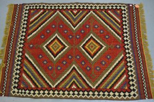 Flatweave rug with a twin medallion design on a red ground with borders, 198 x 146cm approximately