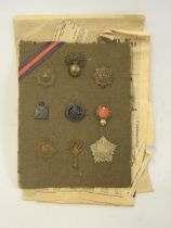 Small quantity of military cap and other badges mounted on a card