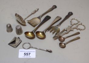 Pair of silver sugar nips, silver skirt lifter, stamp case, an apostle handled sugar sifter spoon,