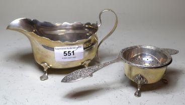 Silver sauce boat and a silver tea strainer