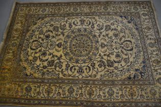 Nain carpet with a medallion and all-over floral design on a beige ground with borders (some moth