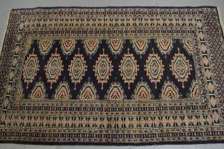 Pakistan rug of Turkoman design with a single row of seven gols on a blue ground with borders, 155 x