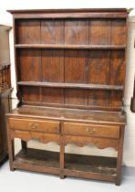 Small 19th Century oak plank top dresser with shelved back, having two short drawers with undertier,