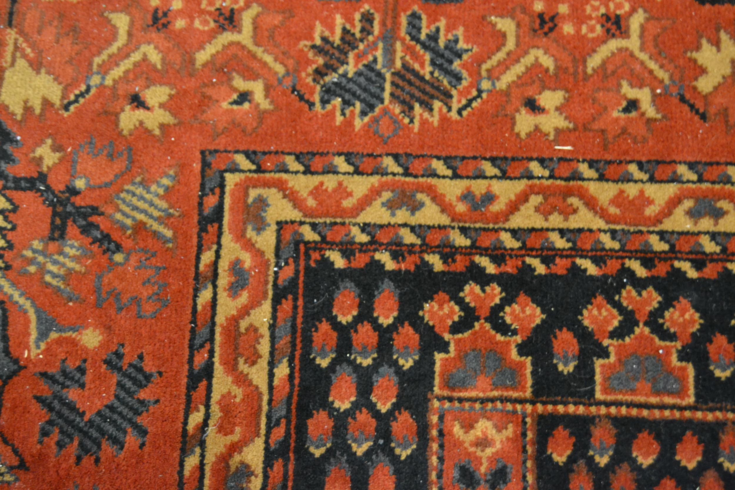 Machine woven Persian design carpet with a rectangular centre panel and dark ground with wide floral - Image 2 of 2