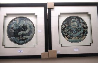 Pair of circular Chinese silk embroidered panels depicting a dragon and an exotic bird on a dark