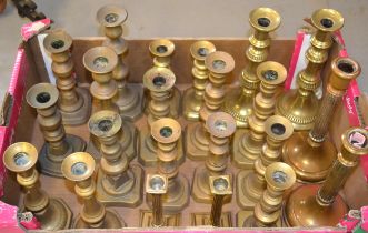 Box containing eleven pairs of brass candlesticks