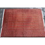 Pakistan Bokhara design carpet, having multiple lines of gols with multiple borders on a rust