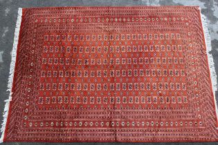 Pakistan Bokhara design carpet, having multiple lines of gols with multiple borders on a rust