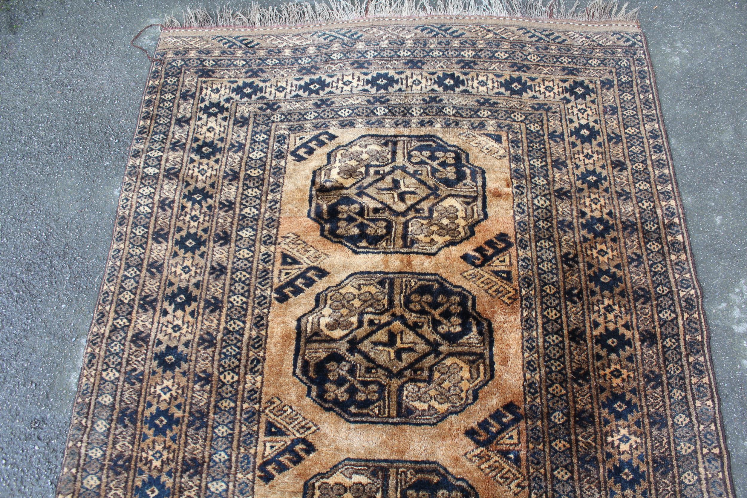 Afghan gold ground rug with three gols and multiple borders, 190 x 133cm approximately - Image 2 of 3