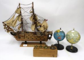 Wooden model of HMS Victory, two miniature metal world globes and a set of five postal weights