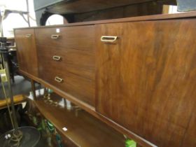 Mid 20th Century teak sideboard with three centre drawers, flanked by cupboard doors, on turned