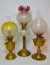 Edwardian brass oil lamp with an etched and tinted glass shade, together with two other similar