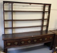 18th Century oak dresser, the open shelved back above a moulded top with four short drawers,