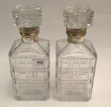 Pair of good quality cut glass square shaped decanters with stoppers and silver mounts 24cm tall,