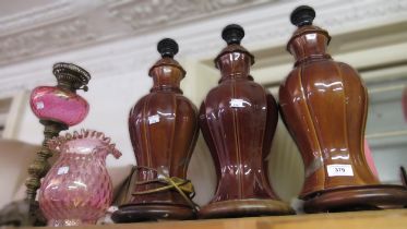 Three matching pottery brown glazed floral decorated lamp bases and an oil lamp with glass well