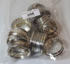 Group of seven various silver napkin rings and a pair of silver mounted bottle tops