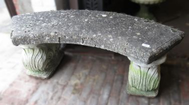 Weathered cast concrete garden bench of curved design with shaped supports, 120cm wide