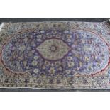 Indo Persian rug with a medallion and all-over palmette design on a mauve ground with borders, 216 x