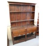 Small 19th Century oak plank top dresser with shelved back, having two short drawers with undertier,