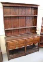 Small 19th Century oak plank top dresser with shelved back, having two short drawers with undertier,