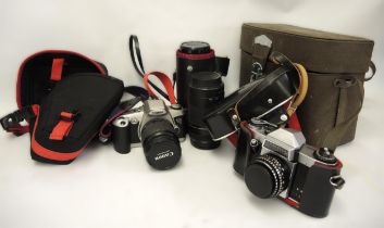 Canon film camera with two lenses, an early Praktica PL Nova camera and another cased lens by