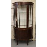 Early 20th Century figured walnut demi-lune display cabinet, the moulded cornice above a bar