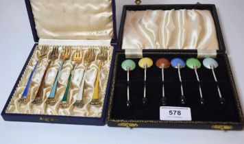 Boxed set of six white metal bean handled coffee spoons with enamelled backs together with a boxed