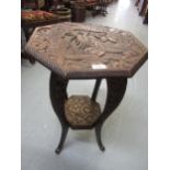 Early 20th Century octagonal two tier occasional table, the top carved with a dragon (retailed by