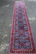 Turkish runner with all-over stylised design on blue ground, 3.6m x 73cm Good condition