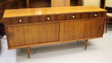 Herbet Gibbs, mid 20th Century teak sideboard, with four drawers above two doors raised on turned