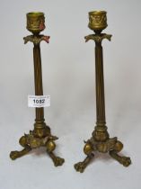 Pair of French bronze candlesticks of slender tapering form, raised on lion's paw feet, 25cm high