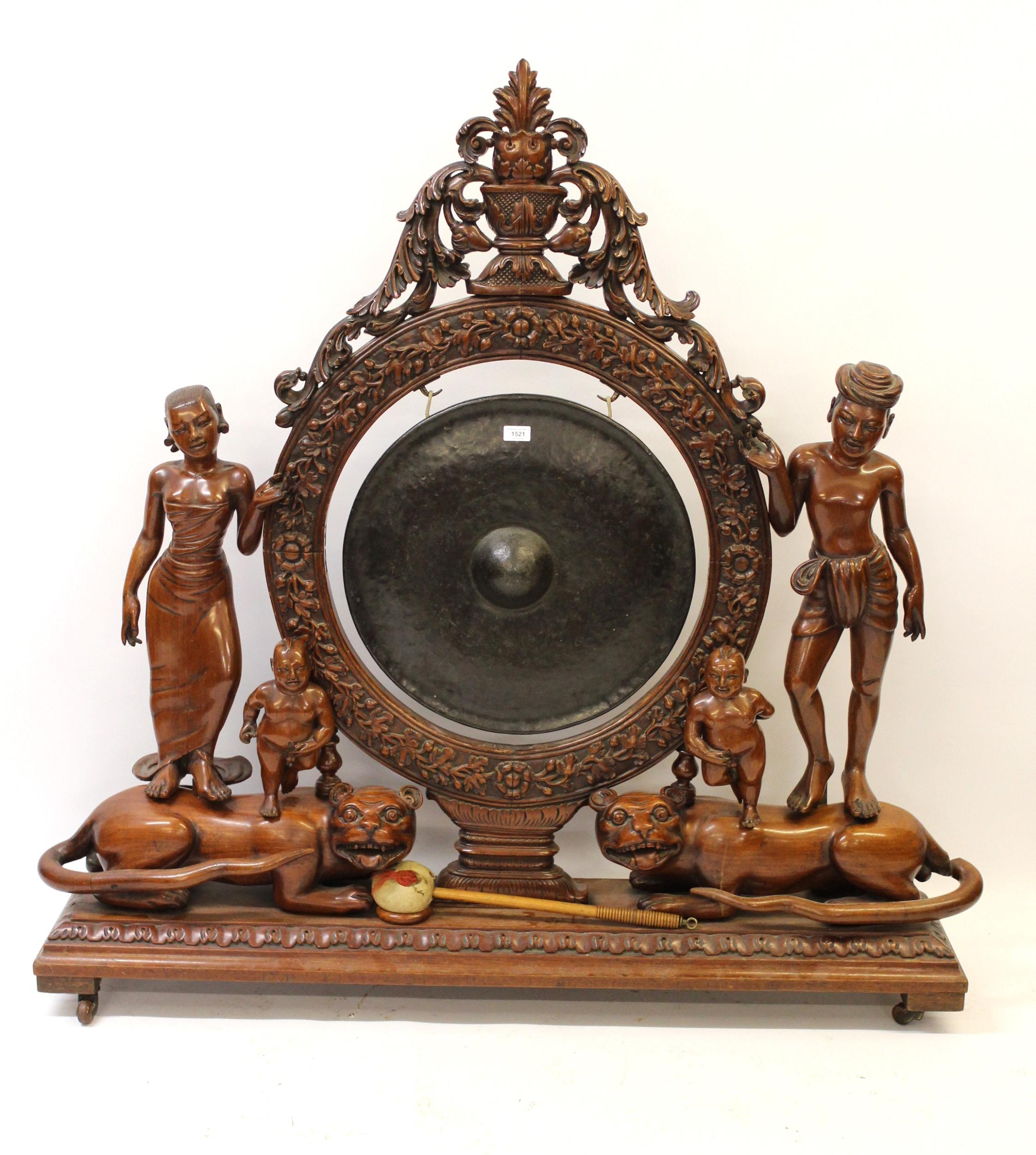 Very large Indonesian carved hardwood gong on stand, the central circular support with profuse all-