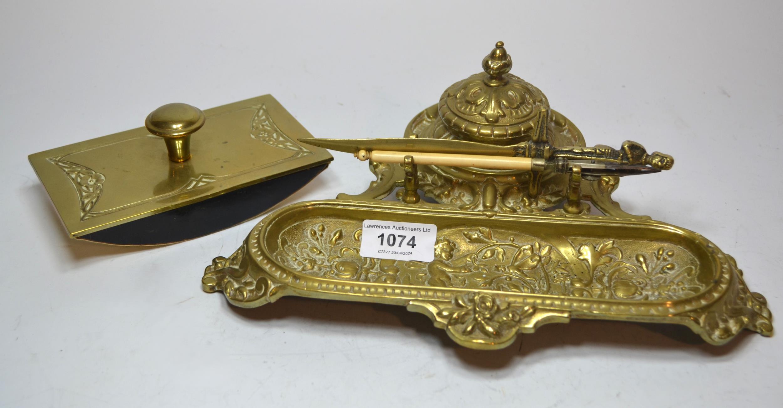 Brass ink stand decorated with cherubs, a paper knife and a brass mounted ink blotter