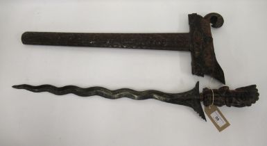 Large Kris dagger having wavy blade with ornately carved hardwood handle and scabbard, 66cm long