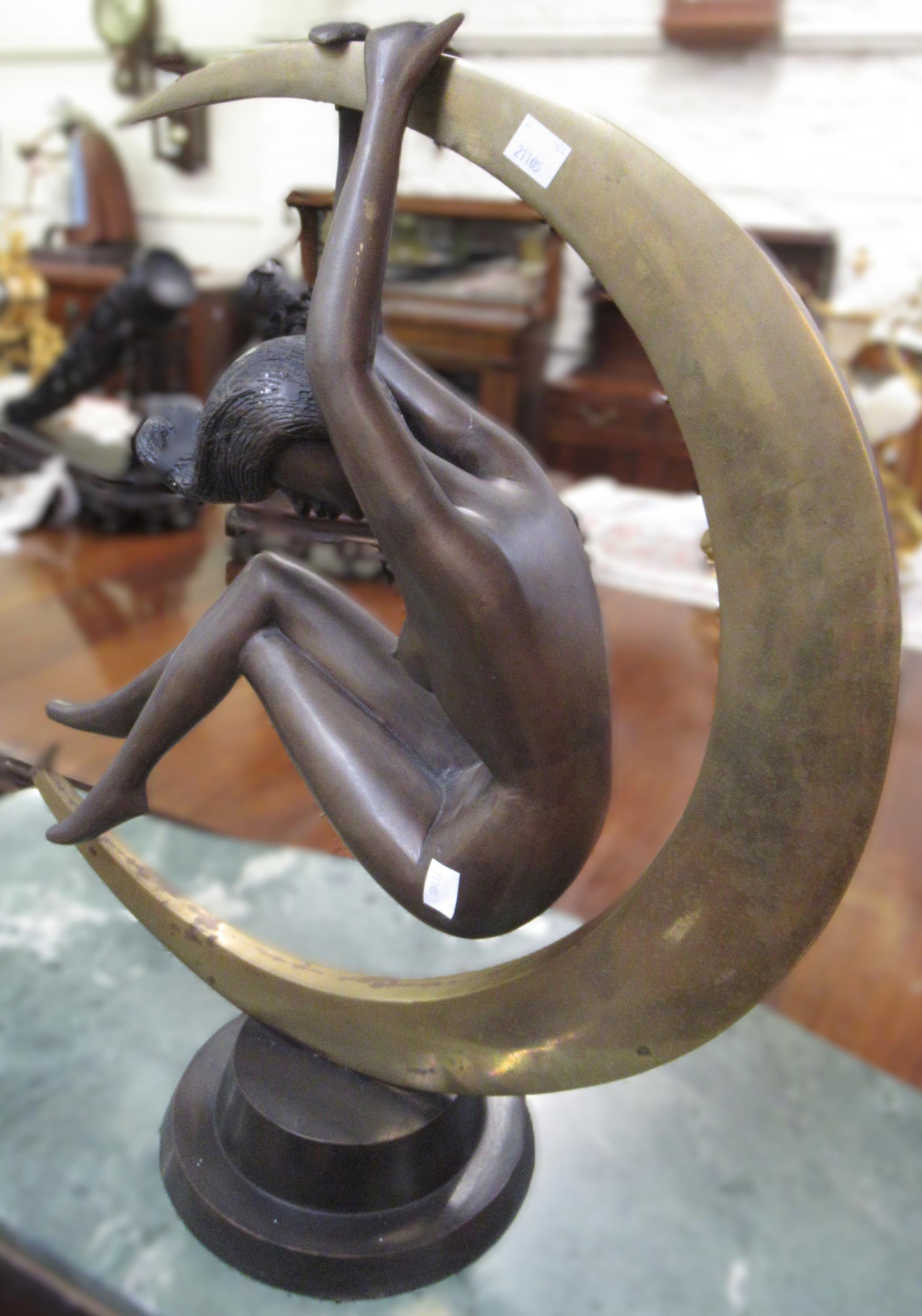 20th Century patinated bronze figure of a female nude suspended from a crescent moon, on a