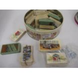 Tin containing a collection of various early cigarette cards including John Players, Wills etc.