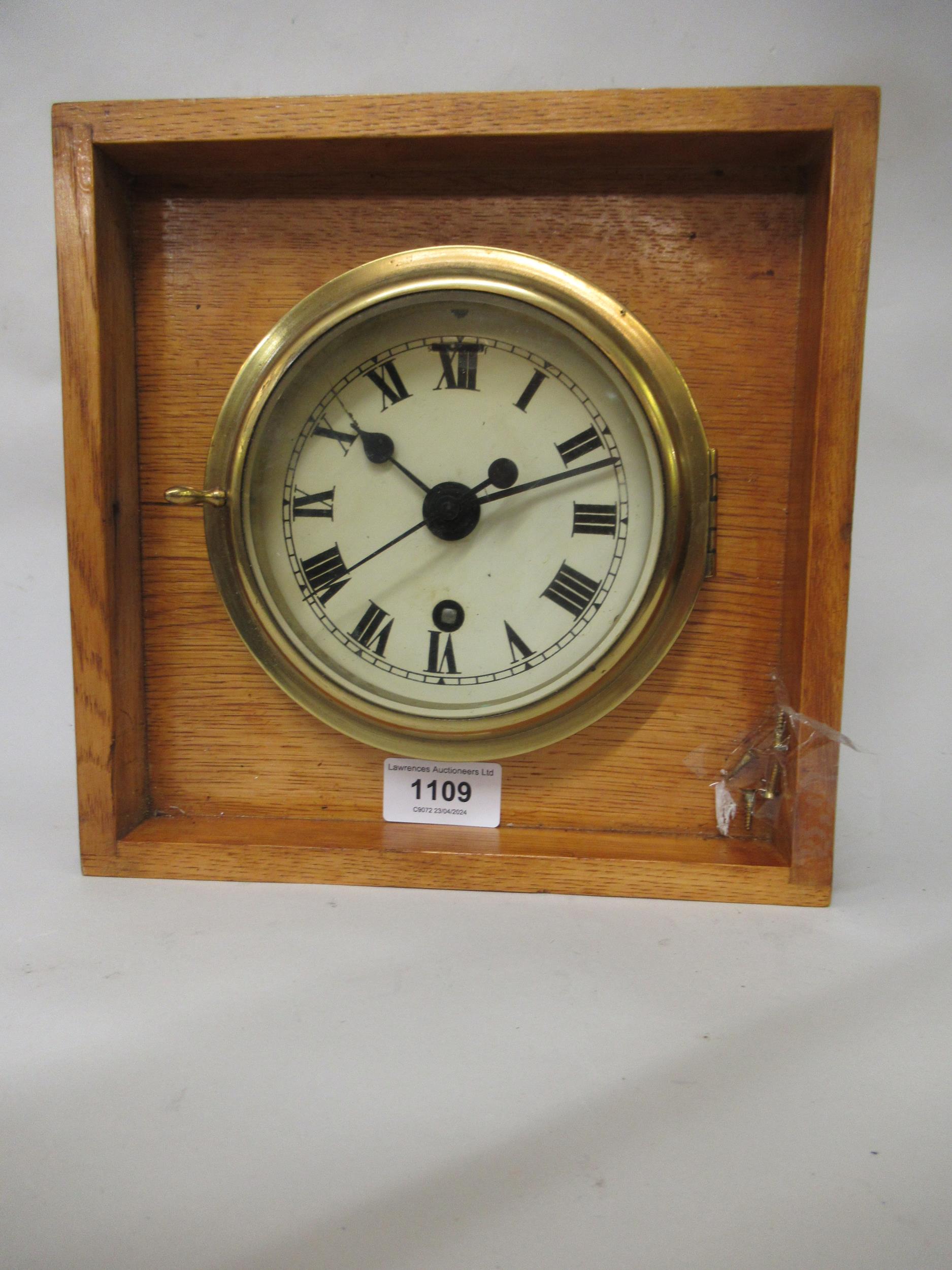 Ship's circular brass bulkhead clock, the enamel dial with Roman numerals, the single train movement