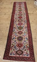 Central Persian runner with repeating hooked medallion design, 316 x 70cm