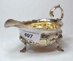 Late George II silver sauce boat with scroll shaped handle, embossed decoration and three hoof