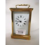 Modern brass cased carriage clock having enamel dial with Roman numerals, including key, 12cm high